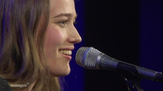 Frontfrau Pia von der Band Dear Robin singt in ein Mikrofon © Screenshot 