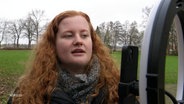 Eine junge Frau mit langen roten Haaren nimmt ein Video auf © Screenshot 