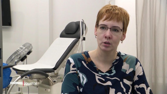 Eine Frau vor einem gynäkologischen Behandlungsstuhl © Screenshot 