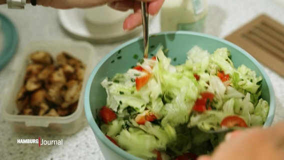 Eine Person bereitet in ihrer Küche einen schmackhaften Salat zu. © Screenshot 