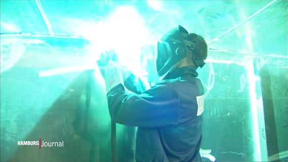 Es leuchtet grell: Eine Person schweißt in Schutzkleidung Metall. © Screenshot 