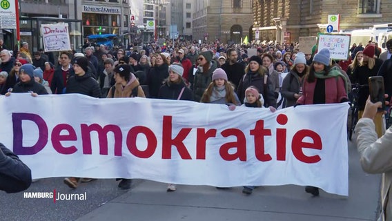 Demonstrierende bei der Demonstration gegen rechts am letzten Wochenende: Menschen tragen ein großes Banner mit der Aufschrift "Demokratie" vor sich her. © Screenshot 