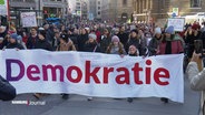 Demonstrierende bei der Demonstration gegen rechts am letzten Wochenende: Menschen tragen ein großes Banner mit der Aufschrift "Demokratie" vor sich her. © Screenshot 