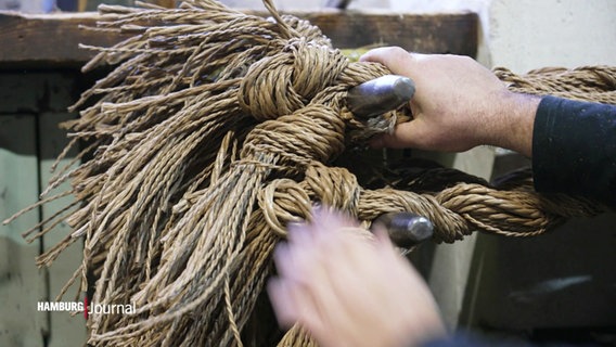 Material für Seile zusammengebunden und befestigt, zwei Hände greifen zu. © Screenshot 