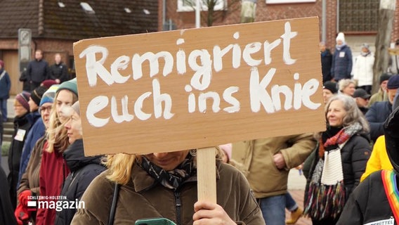 Ein Protestschild mit der Aufschrift: Remigriert euch ins Knie. © Screenshot 