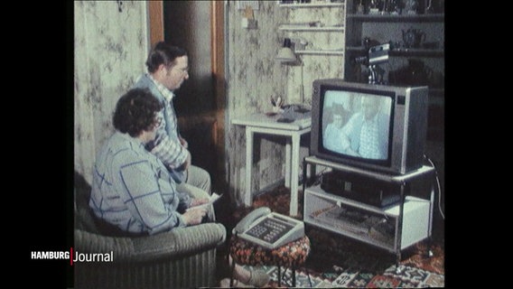 Ein Ehepaar sitzt vor einem Fernseher und sieht sich selbst. © Screenshot 
