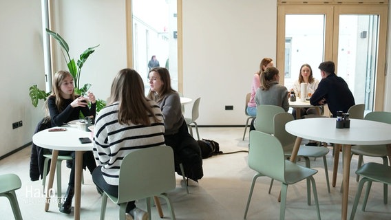 Mitarbeitende einer Lüneburger Digital-Agentur besprechen sich im internen Café. © Screenshot 