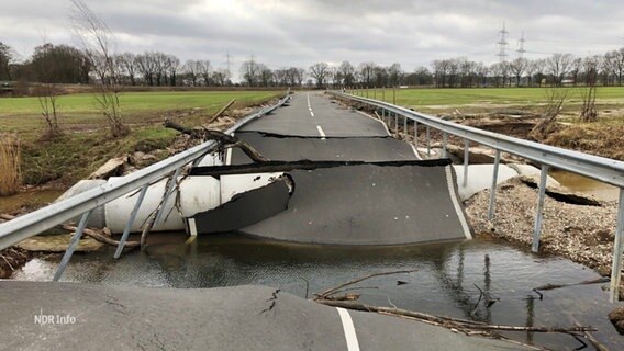 Eine zum Teil unter Wasser stehende Landstraße mit sehr großen Rissen © Screenshot 