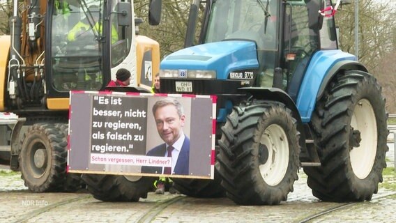 Ein Schild mit einem Foto von Christian Lindner ist an einem Traktor befestigt. © Screenshot 