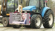 Ein Schild mit einem Foto von Christian Lindner ist an einem Traktor befestigt. © Screenshot 