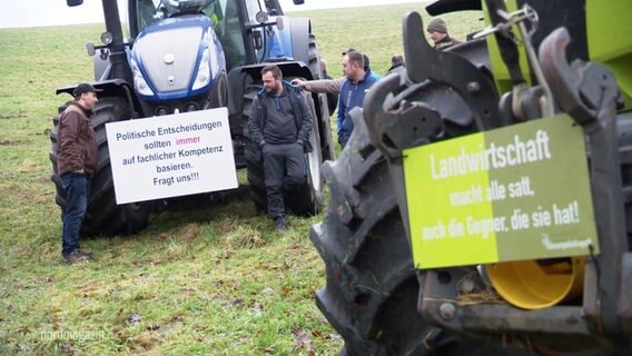 Landwirte stehen um einen Traktor herum. © Screenshot 