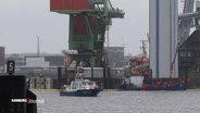 Ein Schiff der Küstenwache sichert die Stelle im Hamburger Hafen, auf der ein Frachtschiff gesunken ist. © Screenshot 