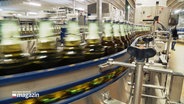 Bierflaschen laufen über durch Förderanlage in einer Fabrik. © Screenshot 