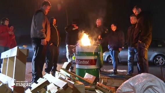 Männer stehen an einer Feuertonne. © Screenshot 