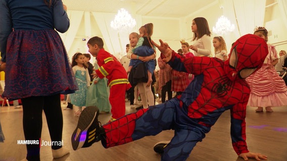 Ein als Spiderman verkleideter Junge macht Breakdance auf dem Boden. © Screenshot 