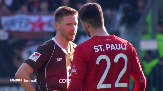 Zwei Spieler des FC St. Pauli stehen sich auf dem Fußballplatz gegenüber und reden. © Screenshot 