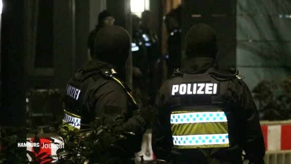 Zwei Polizisten stehen im Dunkeln vor einem Gebäude. © Screenshot 
