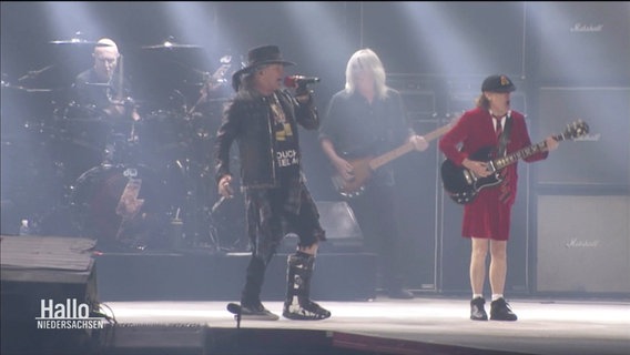 Musiker der Band AC/DC stehen auf einer Bühne. © Screenshot 
