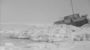 Eine alte schwarz-weiß Aufnahme zeigt ein Boot, das vom Eis eingeschlossen ist. © Screenshot 