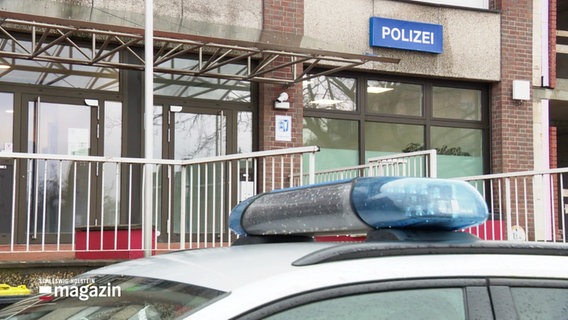 Im Vordergrund das Blaulicht eines Polizeiwagens, im Hintergrund das Schild "Polizei" einer Polizeistation. © Screenshot 