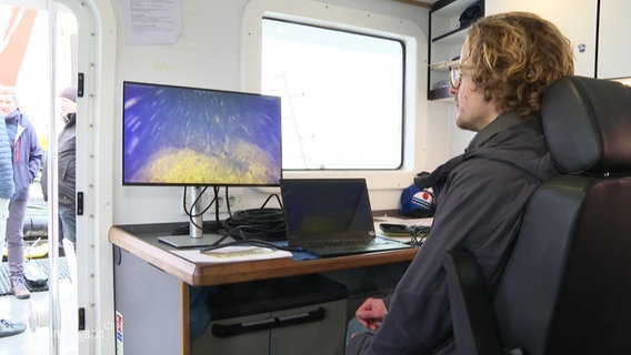 Ein Forscher auf einem Forschungsschiff schut auf einen Bildschirm. © Screenshot 
