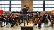 Das Landesjugendorchester spielt für Kinder in Ludwigslust in einer Turnhalle. © Screenshot 