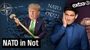 Donald Trump mit einem Vorschlaghammer durchbricht eine Mauer mit NATO-Logo. Daneben Christian Ehring. (extra 3 vom 15.02.2024 im Ersten) © NDR 