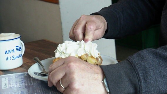 Ein älterer Mann isst ein Stück Kuchen. © Screenshot 