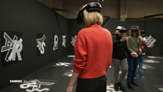 Eine Frau trägt eine VR-Brille. © Screenshot 