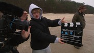 Personen mit Kameraklpappe und Kamera an einem Strand. © Screenshot 