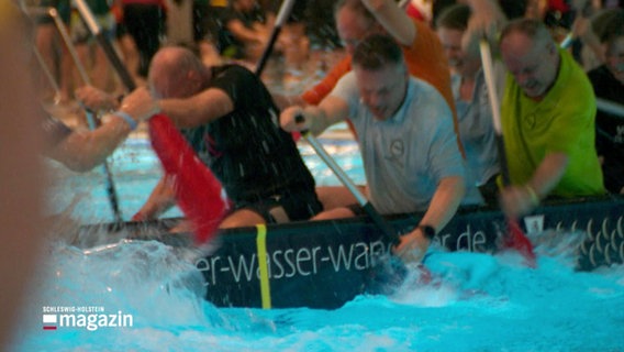 Blick auf ein Team im Drachenboot. Mit aller Kraft hauen sie ihre Rude in das Wasser eines Schwimmbeckens. © Screenshot 