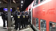Mehrere Polizisten durchsuchen einen Fanzug des HSV in Bergedorf. © Screenshot 