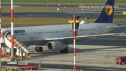 Ein Flugzeug der Lufthansa steht auf einem Rollfeld. © Screenshot 