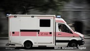 Ein Krankenwagen rast eine Straße entlang. Nachgestellte Szene aus Aktenzeichen XY. © Screenshot 