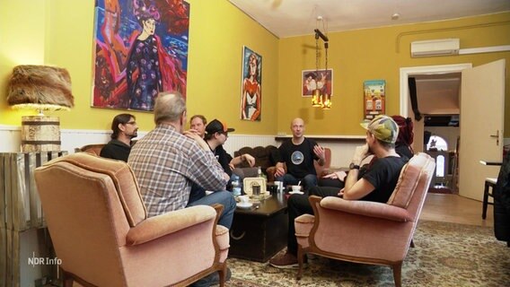 mehrere Menschen sitzen in einem Social Klub. © Screenshot 