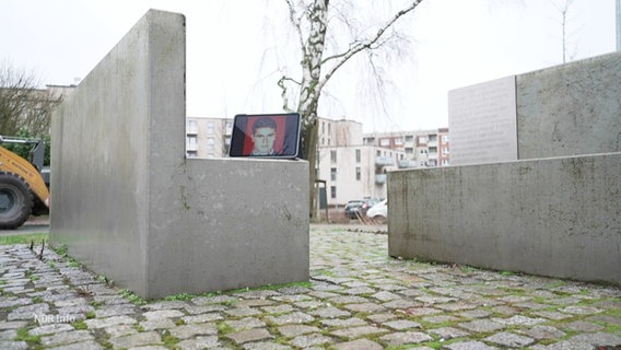 Vor einer Gedenktafel steht ein Tablet, das ein Foto des NSU-Opfers Mehmet Turgut zeigt. © Screenshot 