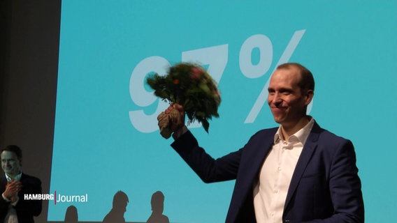 Dennis Thering jubelt mit einem Blumenstrauß in der Hand bei seiner Wiederwahl als Landesvorsitzender der Hamburger CDU 2024. © Screenshot 