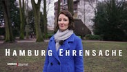 Verena Sahnwald, Eine Frau mit dunklen, kinnlangen Haaren. Sie trägt einen blauen Mantel. Davor der eingefügte Schriftzug "Hamburg Ehrensache". © Screenshot 