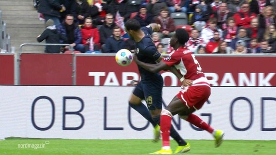 Ein Spieler von Hansa Rostock und ein Spieler von Fortuna Düsseldorf kämpfen um den Ball. © Screenshot 