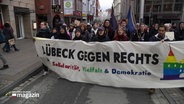 Demonstranten tragen ein Banner mit der Aufschrift: Lübeck gegen rechts. © Screenshot 