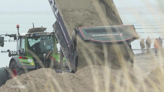Ein Traktor lädt eine große Ladung Sand ab. © Screenshot 