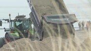 Ein Traktor lädt eine große Ladung Sand ab. © Screenshot 