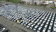 Dutzende neue Autos auf einem Parkplatz. © Screenshot 