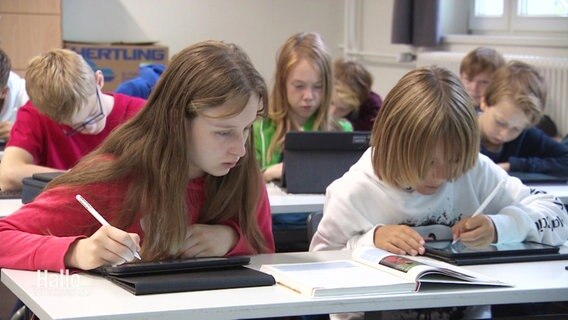 Junge SchülerInnen arbeiten im Schulunterricht mit Tablets. © Screenshot 