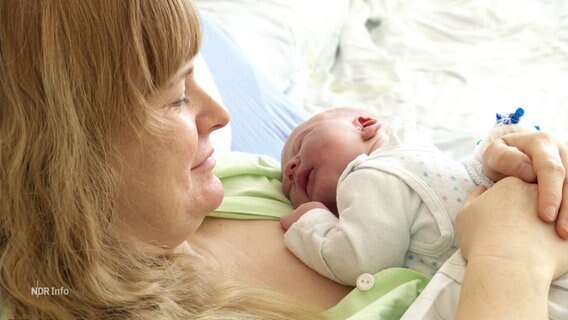 Eine Frau hält ihr neugeborenes Baby in den Armen. © Screenshot 