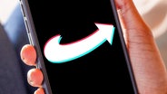 Ein Smartphone in einer Hand, auf dem Display ist das Logo der AfD in TikTok-Optik zu sehen. (extra 3 vom 29.02.2024 im Ersten) © NDR 