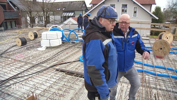 Zwei Männer stehen auf einer Baustelle. © Screenshot 