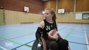 Die Sportlerin Mascha Mosel fährt mit einem Ball im Schoß in ihrem Rollstuhl. © Screenshot 