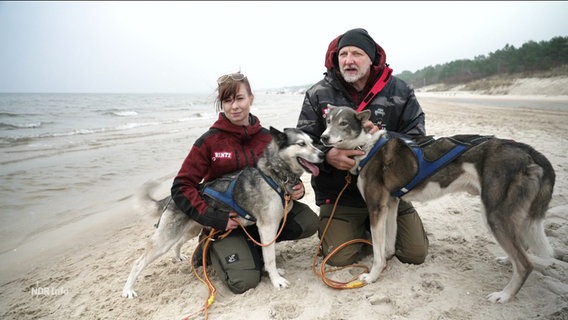Ein Mann und eine Frau mit zwei Hunden am Strand. © Screenshot 