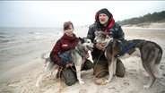 Ein Mann und eine Frau mit zwei Hunden am Strand. © Screenshot 